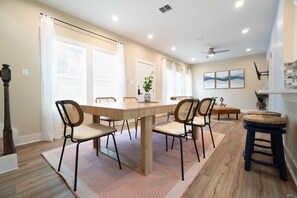 A dining area with a wooden table, four chairs, and a ceiling fan. - Casa Marina ✨ Spacious 3BR • 1 Mile to Pearl & Downtown (San Antonio)