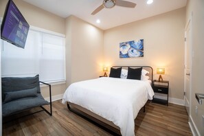 A bedroom with a bed, bedside tables, a chair, a ceiling fan, and a painting on the wall. - Casa Marina ✨ Spacious 3BR • 1 Mile to Pearl & Downtown (San Antonio)