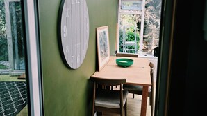 Una habitación con una mesa de madera, una pared verde y un reloj grande.