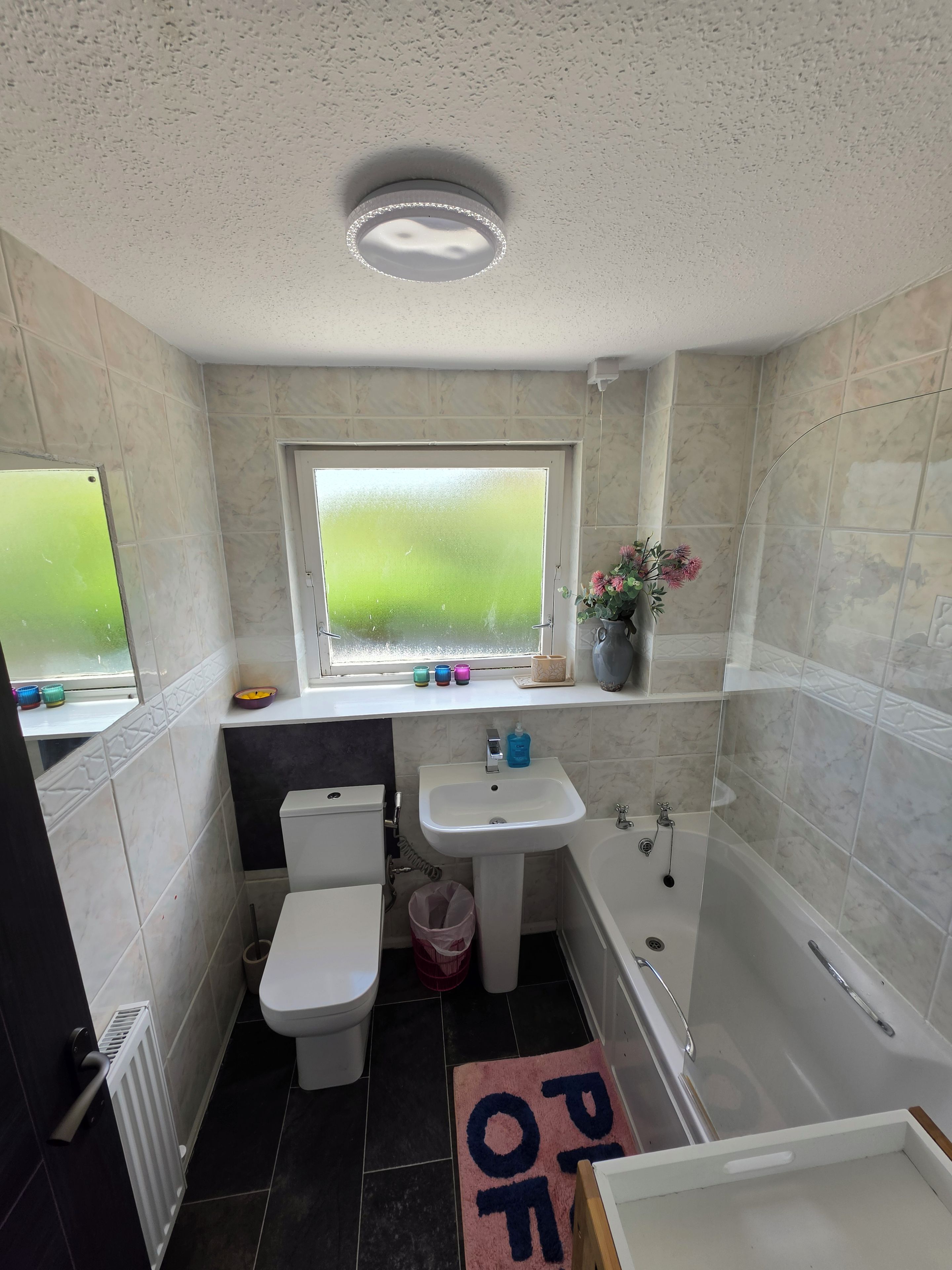 Un baño con inodoro, lavabo, bañera y ventana.