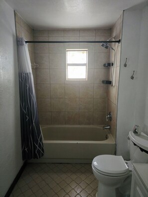 A bathroom with a bathtub, toilet, and a window. - Cozy 1-bedroom for rent in pleasant St. Petersburg with AC (St. Petersburg)