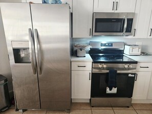 A kitchen with a stainless steel refrigerator, a microwave, a stove, and a toaster. - Cozy 1-bedroom for rent in pleasant St. Petersburg with AC (St. Petersburg)