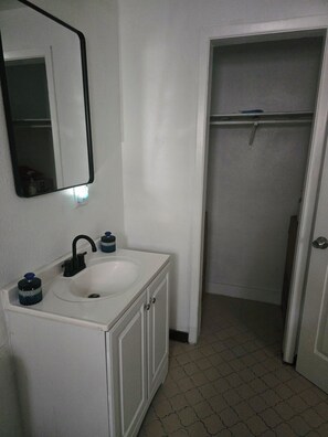 A bathroom with a white sink, a mirror, and a towel rack. - Cozy 1-bedroom for rent in pleasant St. Petersburg with AC (St. Petersburg)