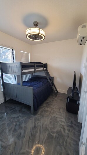 A bunk bed with a ladder, a ceiling fan, and a window with blinds. - Downtown Entertainer's Oasis (San Antonio)