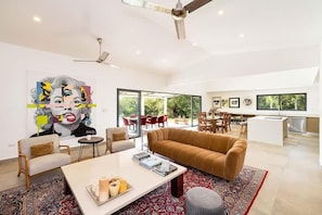 A modern living room with a sofa, coffee table, and artwork on the wall. - 5 Bedroom Villa in Hacienda Pinilla Golf Resort (Hacienda Pinilla)