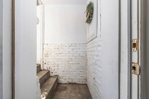 A narrow stairway with white brick walls and a door frame. - Avenue Nook | Pet Friendly | Grill | Desk (Salt Lake City)