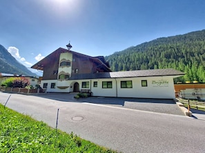A traditional building with a sloped roof, a balcony, and a sign indicating it is a family-friendly establishment. - Ferienhaus Brigitte by Interhome (Längenfeld)