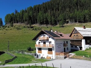 A two-story building with a balcony, a sign reading 'Ferienhaus Disentailer Bergidg,' and a surrounding green landscape. - Dösentaler Bergidyll by Interhome (Mallnitz)