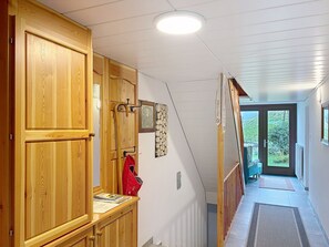 A hallway with wooden doors, a coat rack, and a view of the outdoors through a glass door. - Dösentaler Bergidyll by Interhome (Mallnitz)