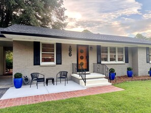 A residential house with a front porch, a door with a circular window, and a number '86' on the wall. - Beech Bungalow • Pool • Hot
Tub • Mid-Century Retreat • Midtown Jackson (Jackson)