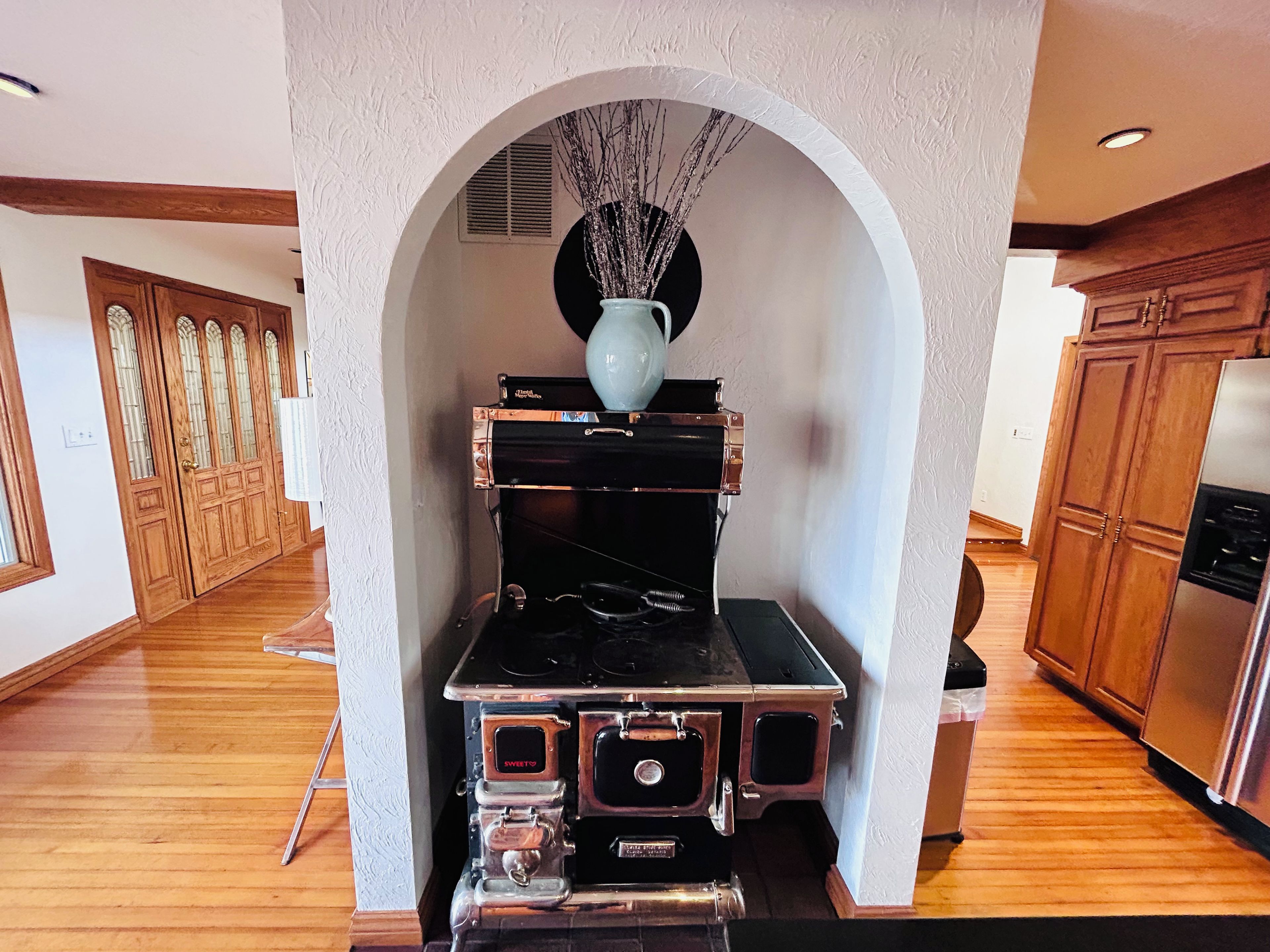 A kitchen with a central island, wooden cabinets, and a decorative vase.