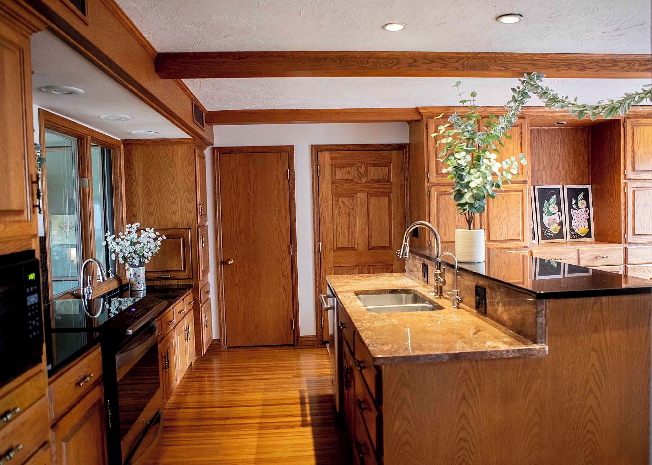 A kitchen with wooden cabinets, a stainless steel sink, and a countertop.