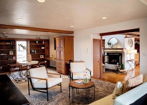 A spacious living room with a fireplace, wooden furniture, and a bookshelf. - Boots & Class, where peaceful Iowa country living meets classy accommodations. (Harlan)