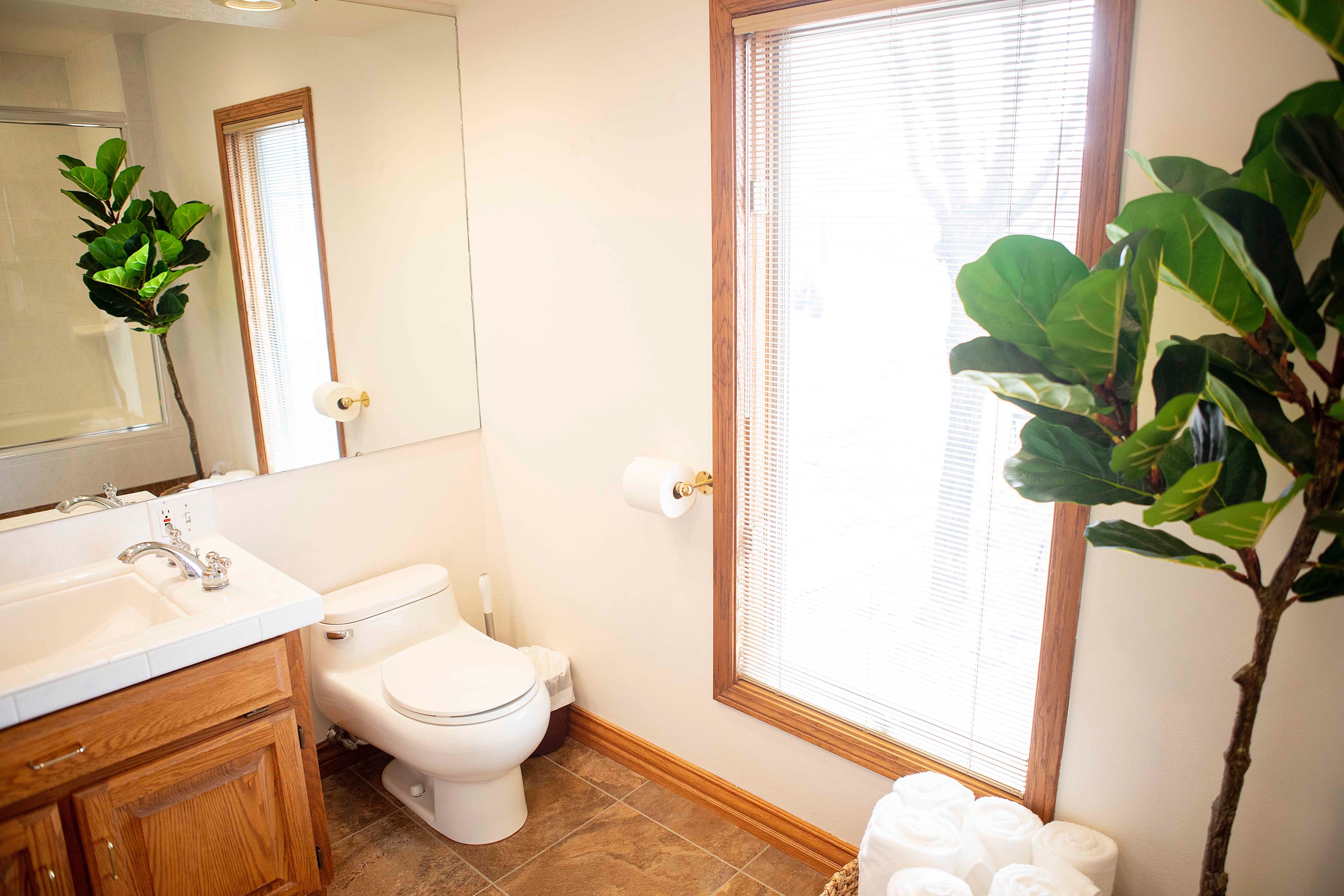 A bathroom with a toilet, sink, and mirror.
