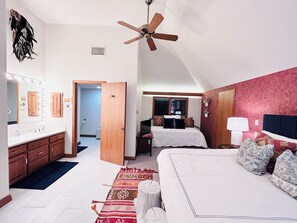 A bedroom with a bed, a ceiling fan, a nightstand, a lamp, a dresser, and a mirror. - Boots & Class, where peaceful Iowa country living meets classy accommodations. (Harlan)