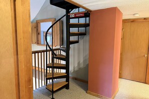 A spiral staircase with a 'FREEFALL' sign, wooden railings, and a carpeted floor. - Cozy Mt Snow Retreat  - Fireplace - Hot Tub -  Sauna (Dover)