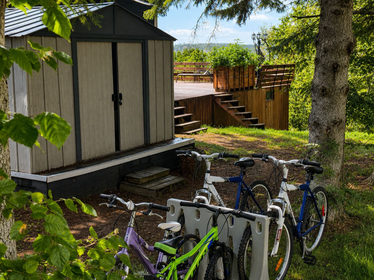 Un abri en bois avec des marches menant à l’entrée, un porte-vélos avec deux vélos, et un escalier en bois.