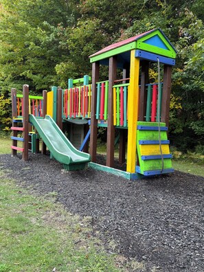 Un parc infantil amb tobogan i elements per escalar.