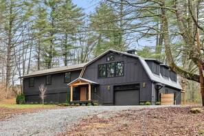 A modern two-story house with a dark exterior, a front porch, and a garage. - 
Walk to Cashiers - 2 king bed rooms + bunk bed with queen, firepit & secluded (Cashiers)