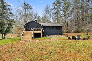 A cabin with a deck, outdoor seating, and a forest backdrop. - 
Walk to Cashiers - 2 king bed rooms + bunk bed with queen, firepit & secluded (Cashiers)