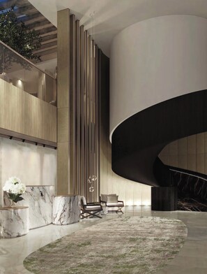 A modern interior with a curved staircase, marble flooring, and a central column with vertical lines. - Stunning Ocean Views 4100 sq ft condo in The Ritz-Carlton Residence (Naples)
