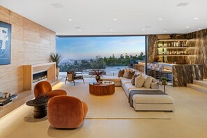 A modern living room with a fireplace, seating area, and a bar with a view. - Spectacular luxury Beverly Hills modern vila views pool and spa (Beverly Hills)