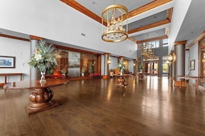 A spacious lobby with a wooden floor, a grand chandelier, and a reception desk. - Great Location! Fireplace! Luxury Bathrooms! (Branson)
