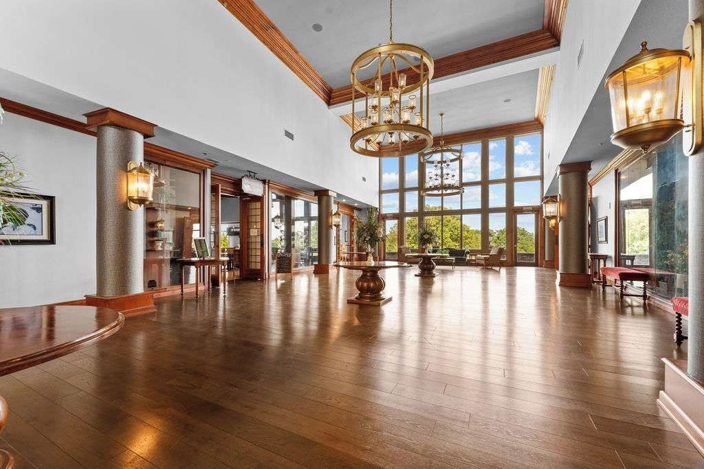 A spacious lobby with high ceilings, large windows, and a grand chandelier.