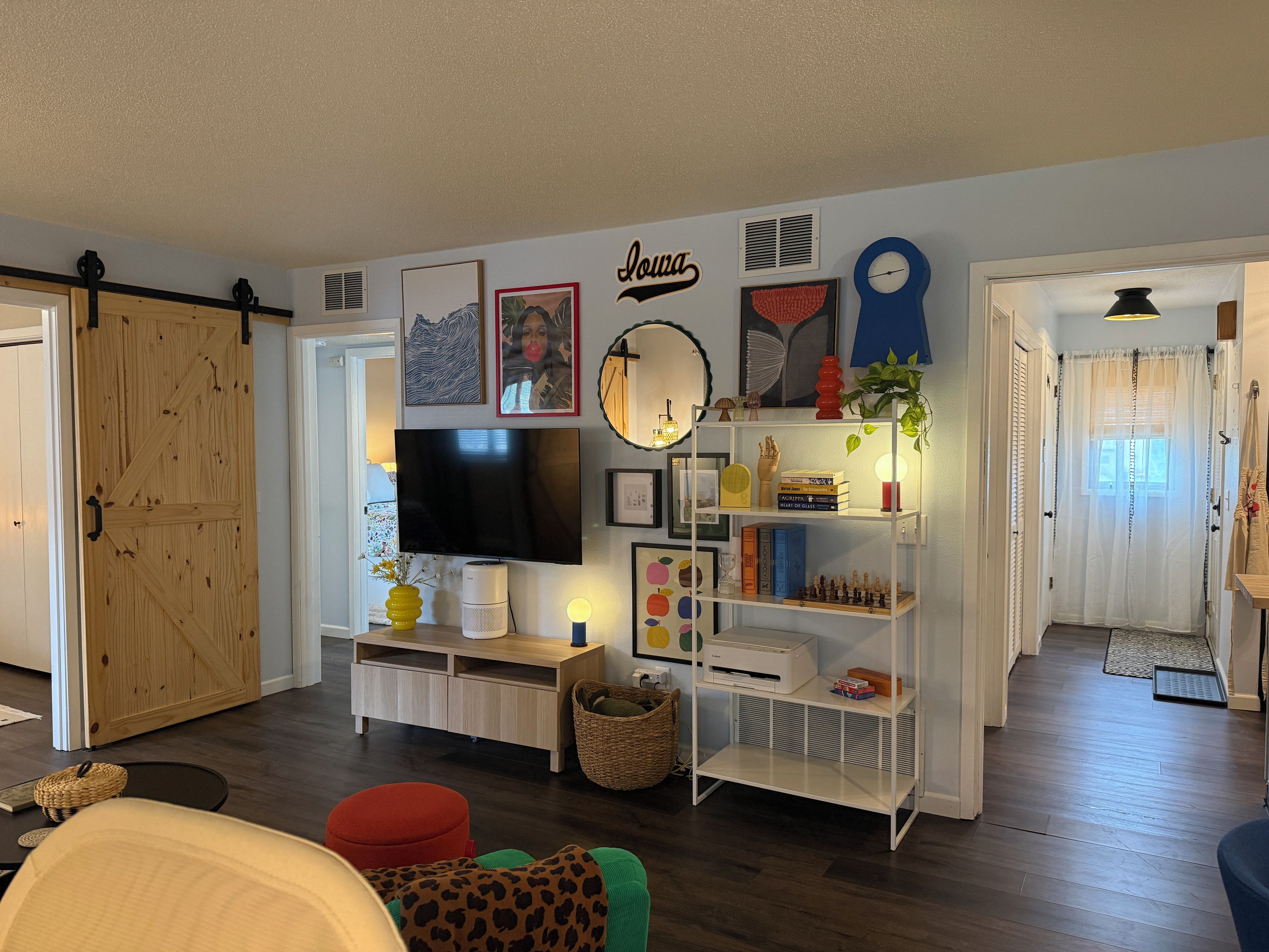 A living room with a television, bookshelf, and a door leading to another room.