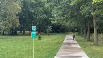 A paved walkway with a sign indicating a trail and a bike path.