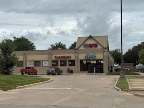 Une pharmacie avec une enseigne indiquant « Magasin de médicaments HARTG », un parking et un camionnette rouge.
