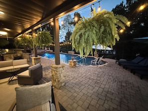 Ein Außenpoolbereich mit Sitzgelegenheiten und einer Pergola.