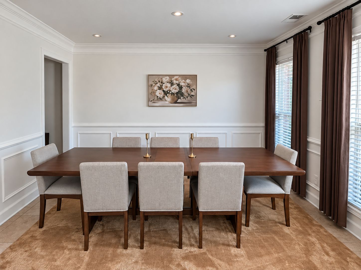 A conference room with a long table, six chairs, and a painting on the wall.