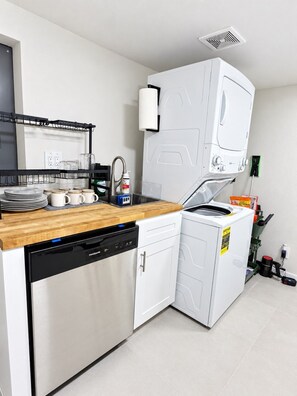 A compact kitchen with a dishwasher, a microwave, and a sink.