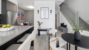 Cozinha moderna com ilha central, espaço para sentar e escada para outro nível.