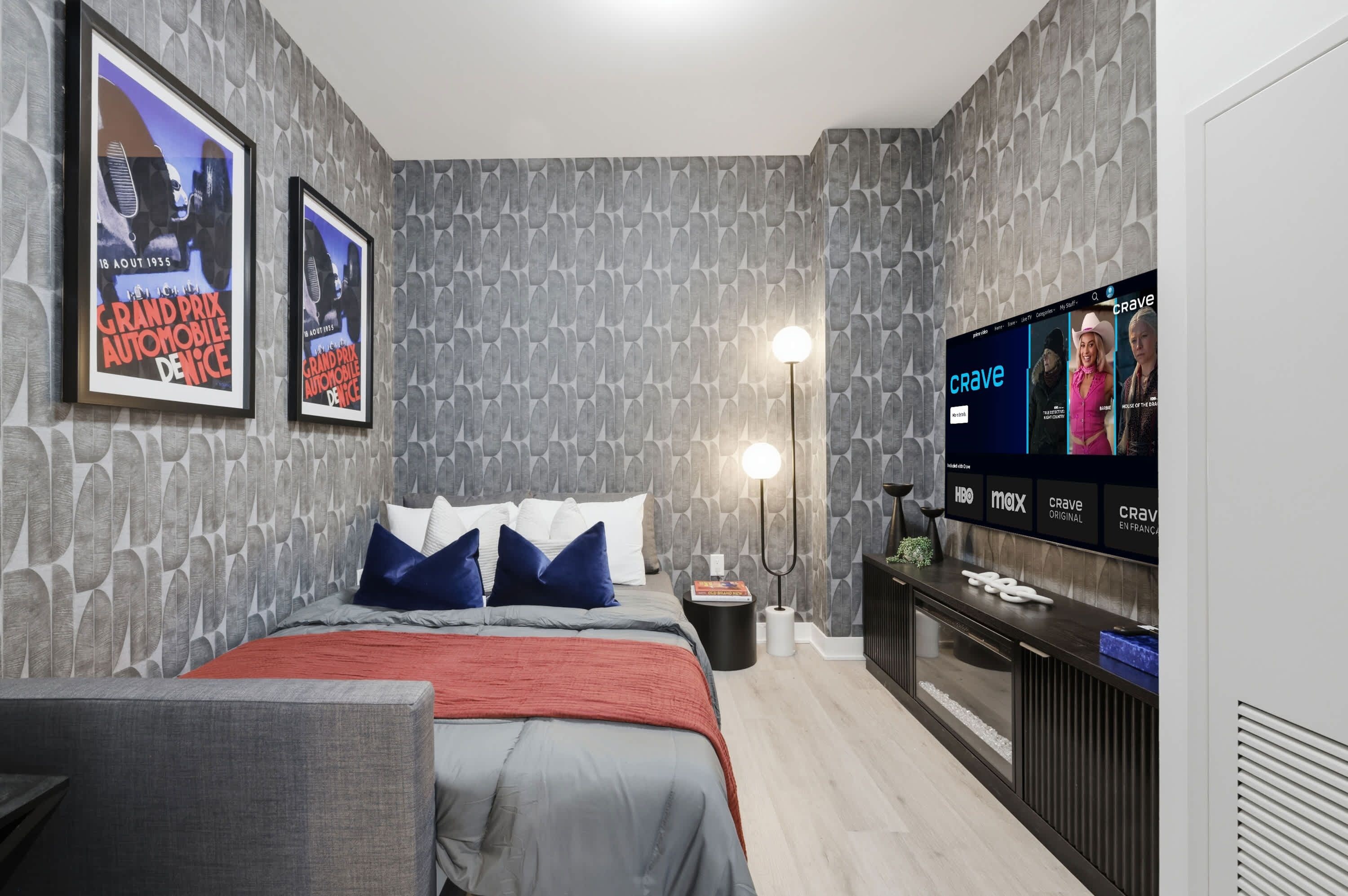 A modern bedroom with a bed, a TV, and a wall-mounted shelf.