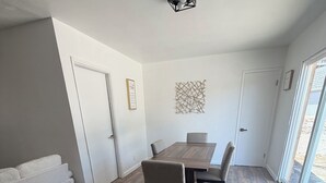 Un interior moderno con una mesa de comedor, sillas, un sofá y un adorno en la pared.