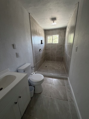 Ein Badezimmer mit Toilette, Waschbecken und Duschbereich.