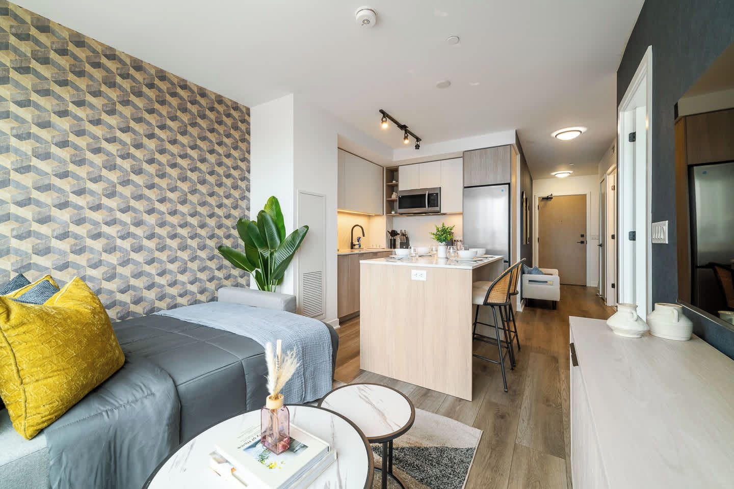 A modern apartment with a living area, kitchen, and dining space.