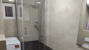 Ein Badezimmer mit einer Duschkabine, einer Toilette und einem Waschbecken.