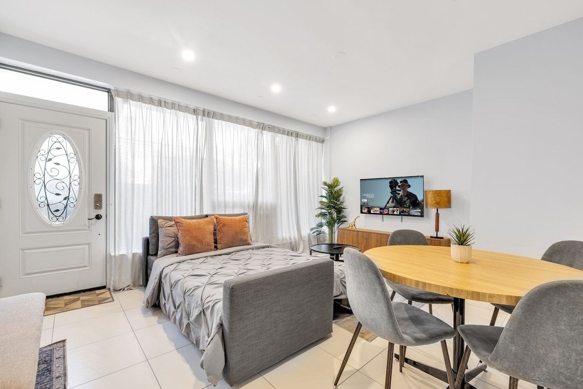 A modern bedroom with a bed, bedside table, and a TV.