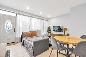 A modern bedroom with a bed, bedside table, and a TV. - Stylish 2BR West End Gem steps to Queen West (Toronto)