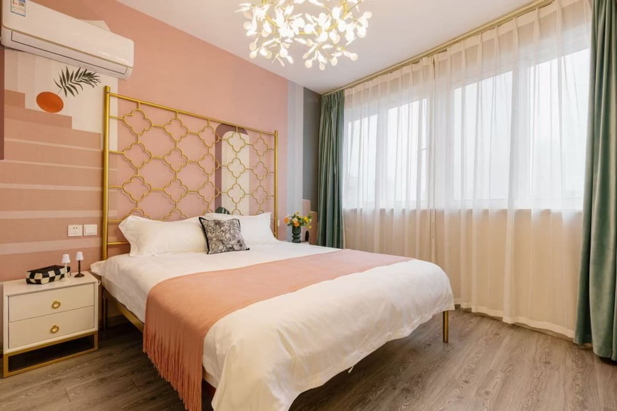 Une chambre à coucher avec un lit, une table de chevet et des rideaux.