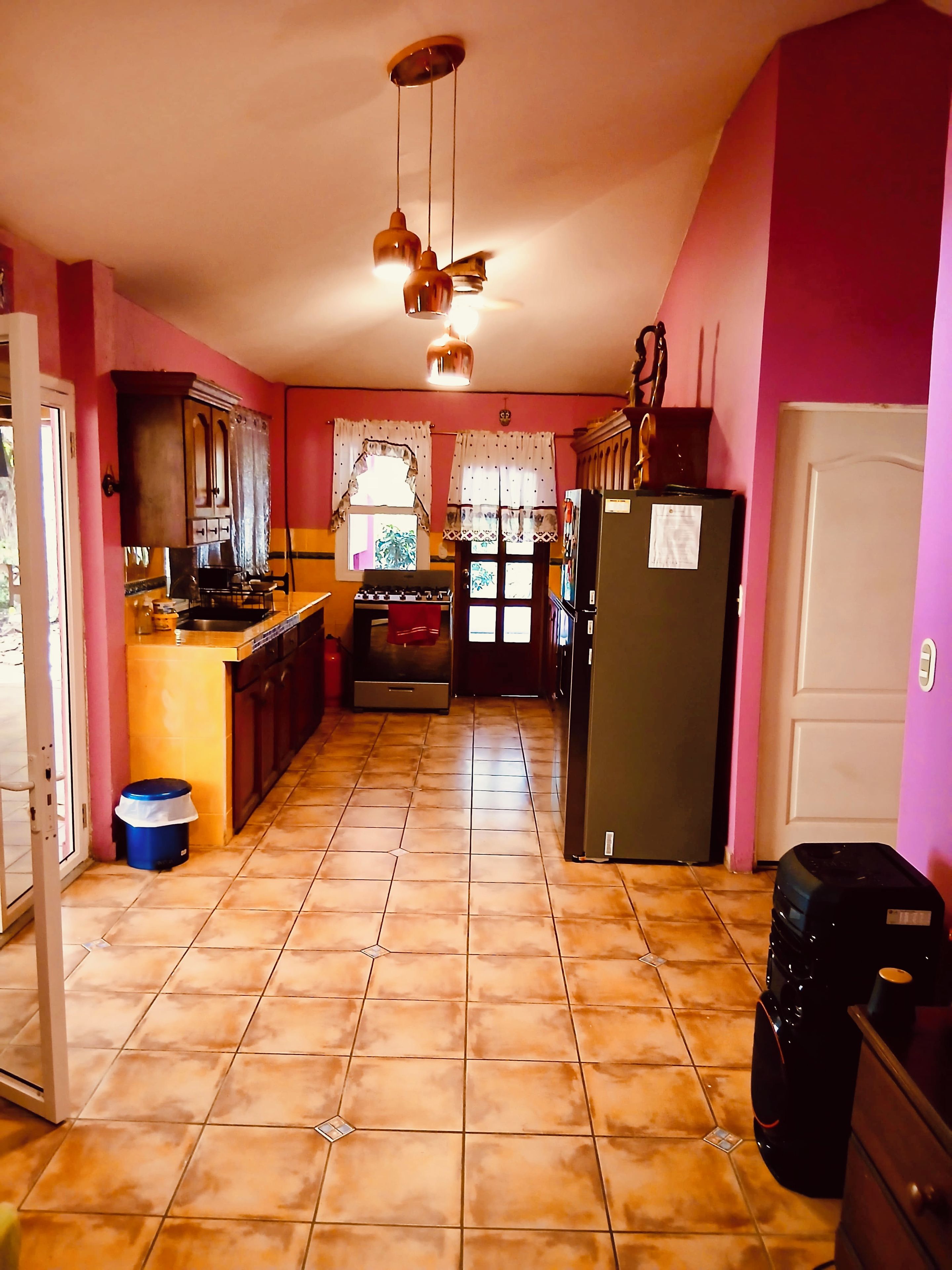 A kitchen with a stove, refrigerator, and cabinets.