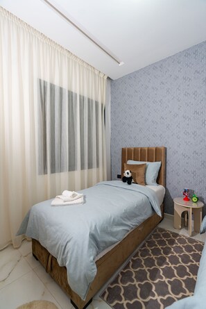 A bedroom with a bed, a nightstand, a teddy bear, and a patterned rug. - Amazing 3-bedroom apartment with AC in charming Tangier (Tangier)