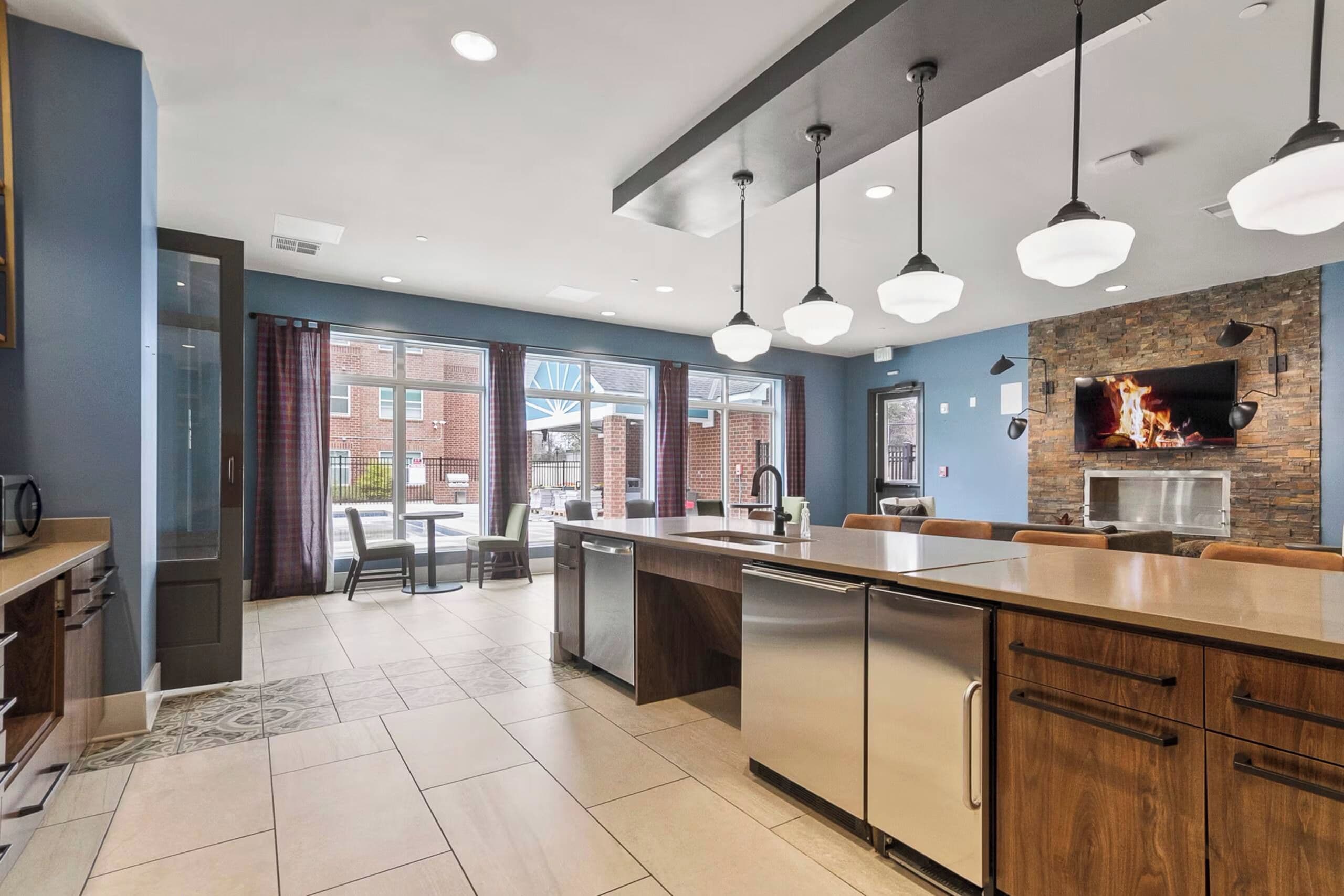 A modern kitchen with a central island, pendant lighting, and a stone accent wall.