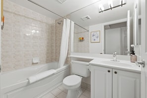 Un baño con bañera, inodoro y lavamanos.