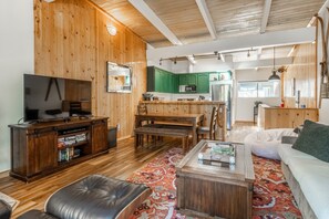 Un salon confortable avec un téléviseur, un canapé en cuir et une table basse.