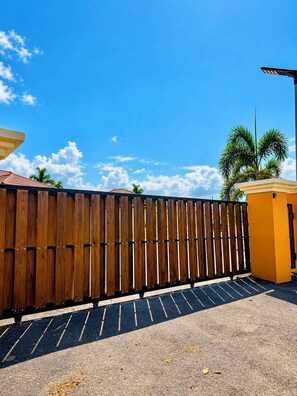 A wooden fence, a yellow building, and a clear blue sky. - Escape to Paradise!| Your Home Away From Home in Jamaica (Runaway bay)