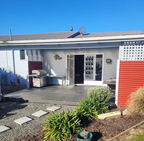 Un immeuble résidentiel doté d’un patio couvert, d’une antenne parabolique et d’une porte de garage.